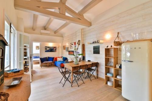 Il dispose d'une cuisine et d'un salon avec une table et un réfrigérateur. dans l'établissement Seaside Villa With Tennis Courts, à Hyères