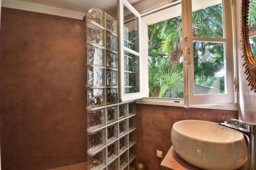 une salle de bain avec un lavabo et une fenêtre dans l'établissement Seaside Villa With Tennis Courts, à Hyères