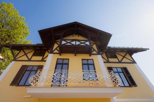 a yellow and black building with a balcony at Alpine Apartements Maximilian in Berchtesgaden