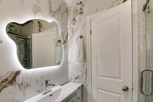 a white bathroom with a sink and a mirror at Beautiful house near bluffers beach, 25 minutes to Toronto Downtown, free parking, and wifi in Toronto