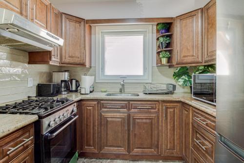a kitchen with wooden cabinets and a sink and a window at Beautiful house near bluffers beach, 25 minutes to Toronto Downtown, free parking, and wifi in Toronto