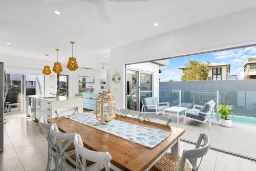 a kitchen and living room with a table and chairs at Luxury Living with Heated Pool in Birtinya in Kawana Waters