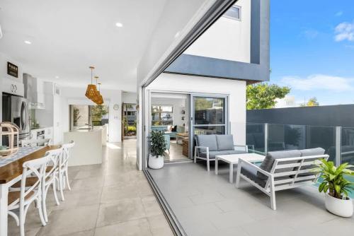 a kitchen and living room with a table and chairs at Luxury Living with Heated Pool in Birtinya in Kawana Waters