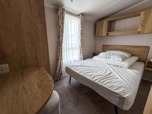 ヘムズビーにあるStunning Caravan With Side Decking Just A Short Walk To Hembsy Beach Ref 00069Baのベッドルーム1室(テーブル、窓付)