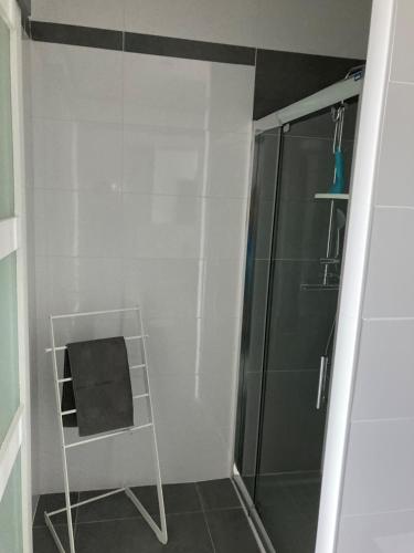La salle de bains est pourvue d'une douche et d'une chaise noire. dans l'établissement Villa Moderne, à Castelnau-de-Guers