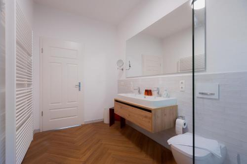 a white bathroom with a sink and a toilet at Alpine Apartements Maximilian in Berchtesgaden
