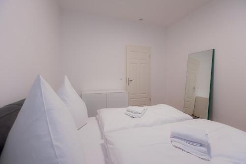 two beds in a white room with white walls at Alpine Apartements Maximilian in Berchtesgaden