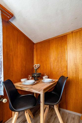 a wooden table with two black chairs around it at Chalet In The Countryside Kitchen Parking Lot in Spiez