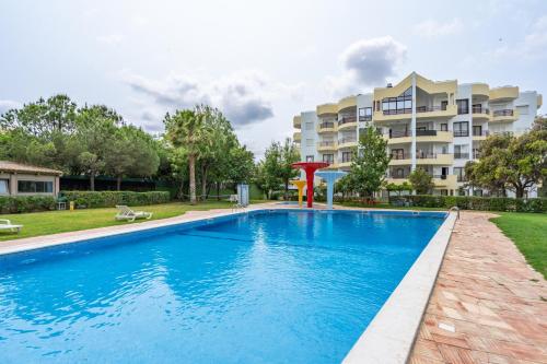 a swimming pool in front of a apartment building at HostWise - Sunny Flat Near Praia da Rocha in Portimão