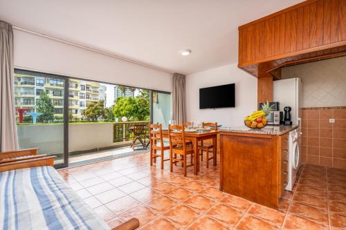 a kitchen and dining room with a table and chairs at HostWise - Sunny Flat Near Praia da Rocha in Portimão