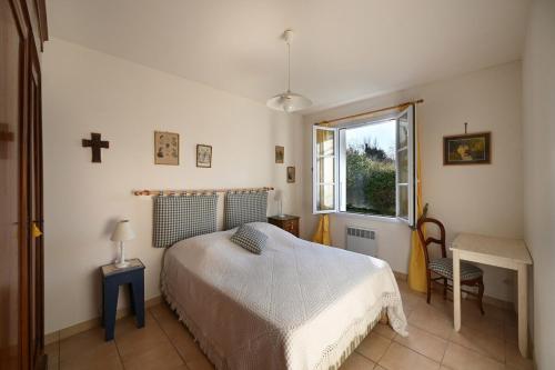 - une chambre avec un lit et une croix sur le mur dans l'établissement 299 Les Peupliers, à La Couarde-sur-Mer