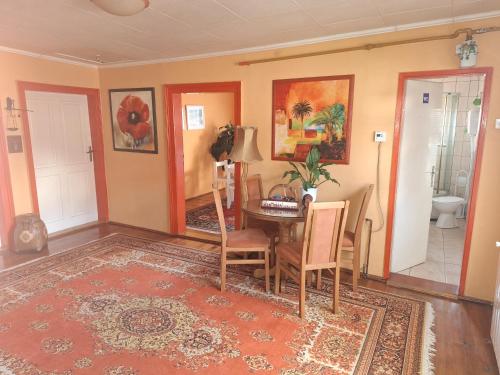 a living room with a table and chairs and a bathroom at Modern&Cozy Bosnian house with GARDEN+FREE parking in Sarajevo