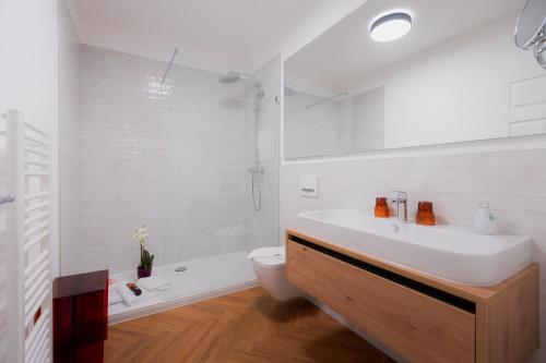 a bathroom with a sink and a toilet and a tub at Alpine Apartements Maximilian in Berchtesgaden