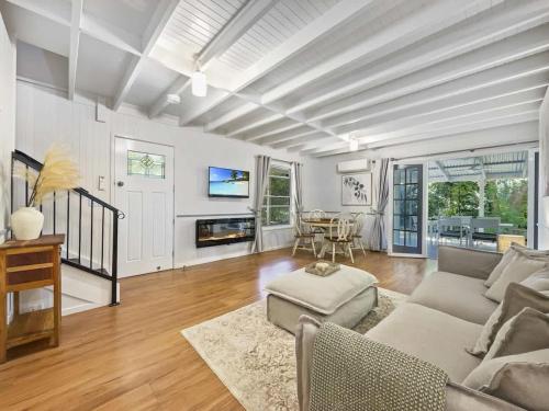a living room with a couch and a table at Puddleduck Cottage - Garden Hideaway Near Maleny in Balmoral Ridge