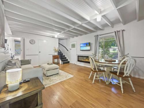 a living room with a table and a couch at Puddleduck Cottage - Garden Hideaway Near Maleny in Balmoral Ridge