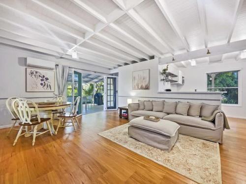 a living room with a couch and a table at Puddleduck Cottage - Garden Hideaway Near Maleny in Balmoral Ridge