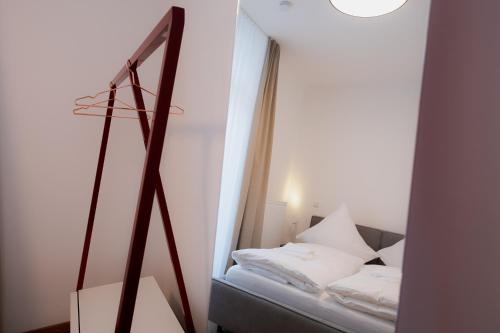 a small bedroom with a bed and a mirror at Alpine Apartements Maximilian in Berchtesgaden