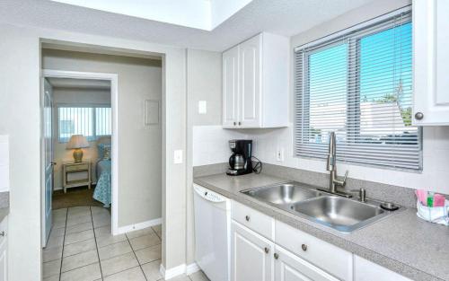 a white kitchen with a sink and a window at Crescent Royale Condominiums 201 in Siesta Key