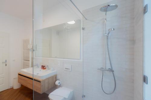 a bathroom with a shower and a toilet and a sink at Alpine Apartements Maximilian in Berchtesgaden