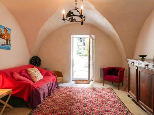 - un salon avec un canapé rouge et un tapis rouge dans l'établissement Maison typique en plein cœur du village, à Châtillon-en-Diois