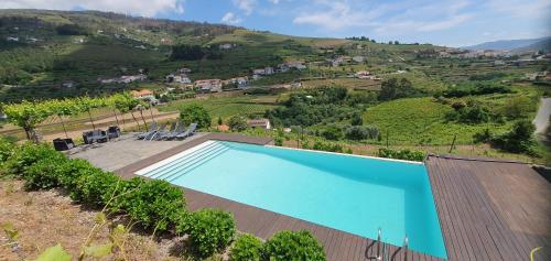 a swimming pool on the side of a house at Quinta do Santo no Douro - Casa T2 in Alcarias