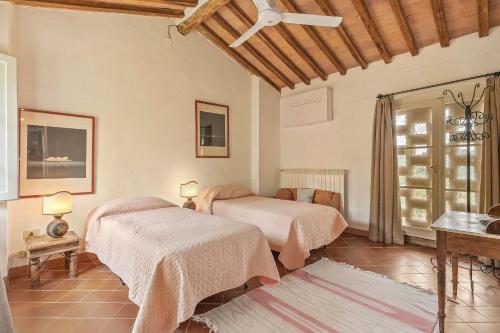 a bedroom with two beds and a window at Centolivi 12 by Salogi Villas in Montecastello