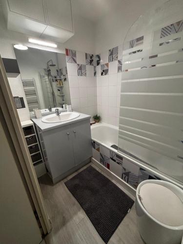 une salle de bain avec un lavabo, une baignoire et des toilettes dans l'établissement Appartement T2 Le galant vert, à Aucamville
