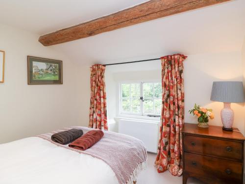 a bedroom with a bed and a window at Magdalen Cottage in Banbury