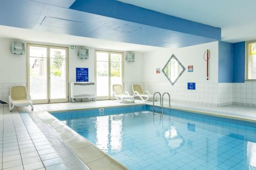 une grande piscine aux murs bleus et au plafond bleu dans l'établissement Résidence Odalys Le Domaine des Rois, à Bergheim
