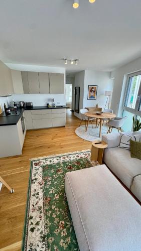 a living room with a couch and a kitchen at Mosel Home Apartments - Netflix - modern & zentral in Schweich