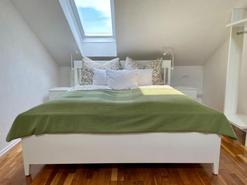 a bedroom with a large bed with a green blanket at Moderne Oase mit Panorama-Blick in Villach