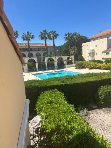 - une piscine dans une cour arborée et un bâtiment dans l'établissement Mazet climatisé avec piscine Mer à 700m, Le Lavandou Bormes, au Lavandou