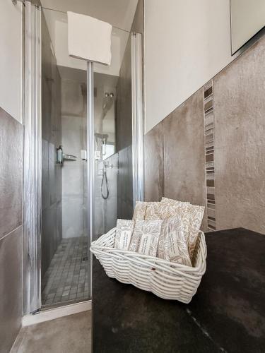 a bathroom with a shower and a wicker chair at Hotel Bella Igea in Bellaria-Igea Marina