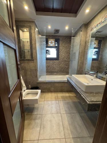 a bathroom with a sink and a toilet and a tub at villa c182 in Sheikh Zayed