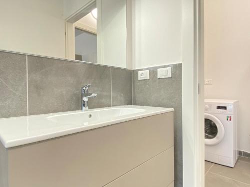 a bathroom with a sink and a washing machine at Suite Emilia 8 in Bologna