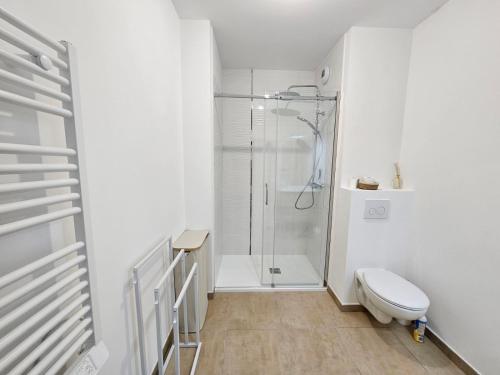 une salle de bain blanche avec douche et toilettes dans l'établissement Appartement neuf, 200m de la plage de Fréjus, à Fréjus