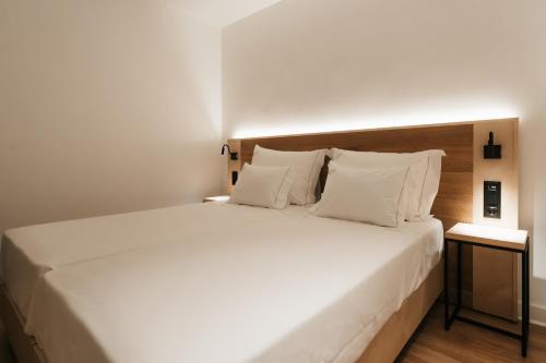 a bedroom with a large bed with white sheets and pillows at Casa do Parque Nature & Heritage Hotel in Castelo de Vide