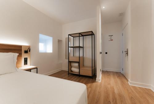 a bedroom with a white bed and a closet at Casa do Parque Nature & Heritage Hotel in Castelo de Vide