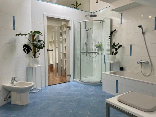 a bathroom with a shower and a tub and a sink at Moderne Oase mit Panorama-Blick in Villach