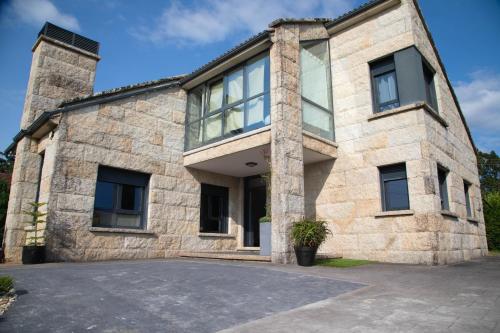 a large stone building with a lot of windows at GALIHOST - Villa Gandara in Ribadumia