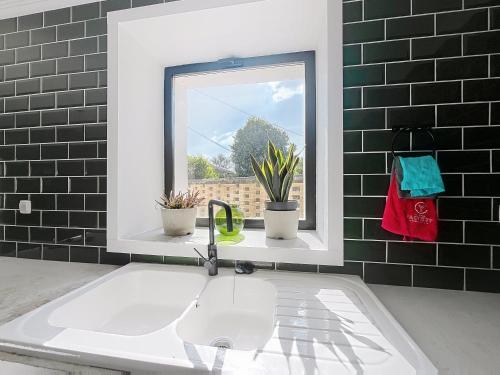 La salle de bains est pourvue d'un lavabo et d'une fenêtre. dans l'établissement Maison en pierre proche Blayais, à Saint-Girons-dʼAiguevives