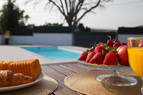a table with a plate of fruit and a glass of orange juice at GALIHOST - Villa Gandara in Ribadumia