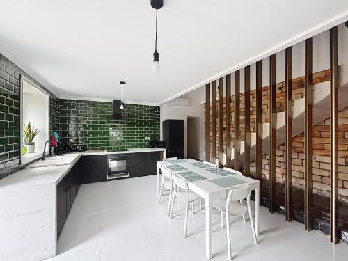 une cuisine avec une table et des chaises dans une pièce dans l'établissement Maison en pierre proche Blayais, à Saint-Girons-dʼAiguevives