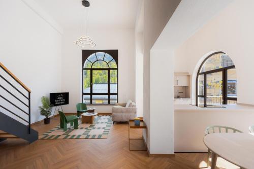 a living room with white walls and windows and a kitchen at Alpine Apartements Maximilian in Berchtesgaden