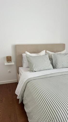 a bedroom with two beds with striped blankets and pillows at City Center House - Azure Waters in Ribeira Grande