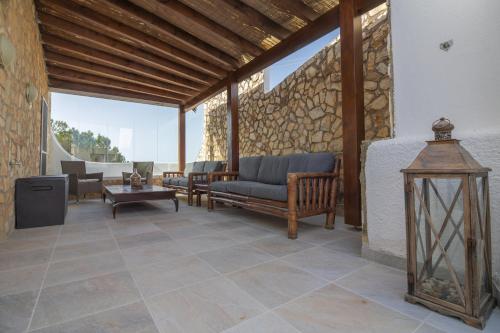 a patio with furniture and a stone wall at Casa Jana 5 Bedroom House for 12 with Ocean View Terrace near the Beach in Burgau