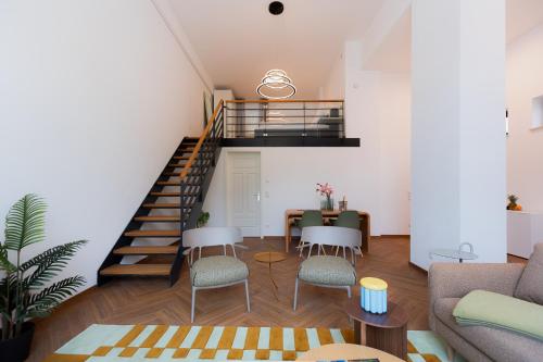 a living room with a staircase and a table and chairs at Alpine Apartements Maximilian in Berchtesgaden