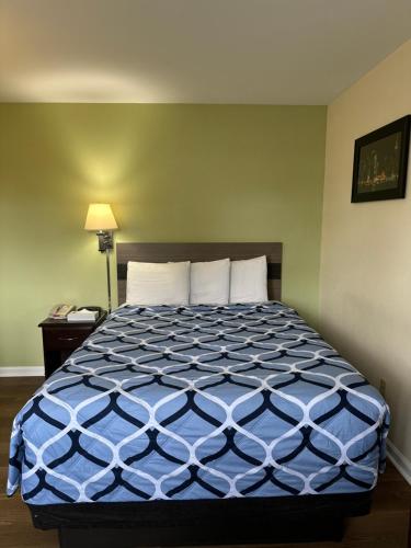 a bedroom with a bed with a blue comforter at Sea Girt Lodge in Sea Girt