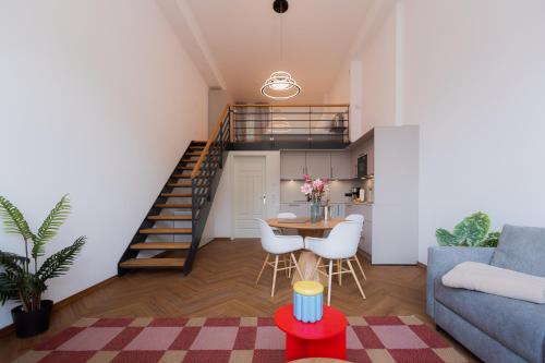 a living room with a staircase and a table and chairs at Alpine Apartements Maximilian in Berchtesgaden