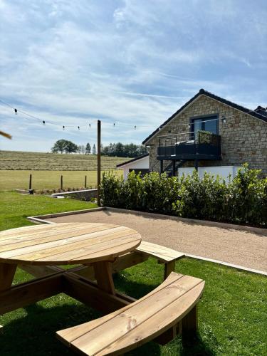 a wooden picnic table in front of a house at Pit & Lodge in Malmedy